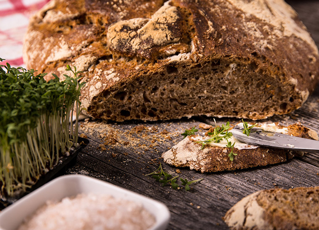 Ein Laib Brot mit Salz und Kräutern auf einem Tisch.