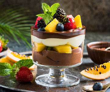 Ein Schokoladendessert im Glas mit Früchten und Minze.