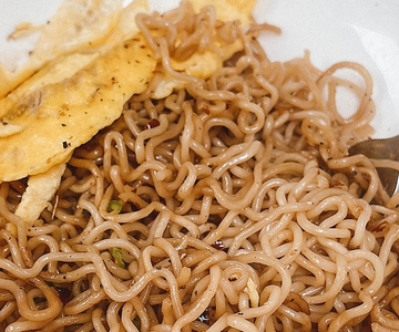 Ein Teller mit Ramen-Nudeln und einem Omelett.