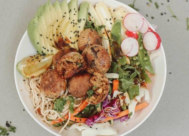 Eine Schüssel Nudeln mit Auberginenkroketten, Avocado, Kohl und Radieschen.