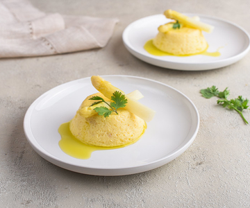 Zwei weisse Teller mit zwei Spargelflan darauf.