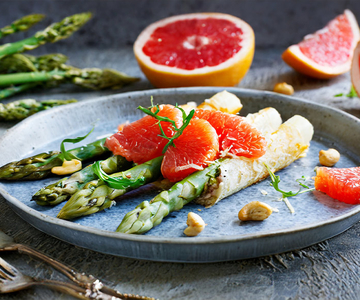 Ein Teller mit Spargel im Cashewmanten und Grapefruit.