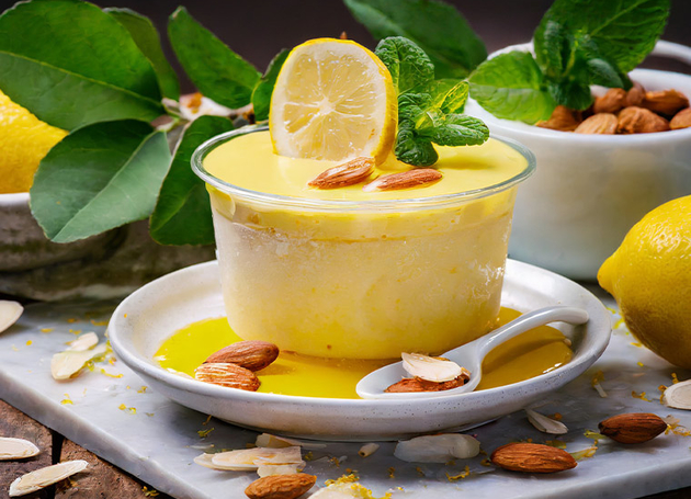 Ein Dessert aus Zitronen-Quark und Mandeln in einer gläsernen Schüssel.