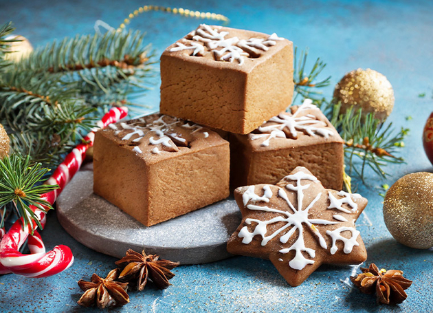 Lebkuchenwürfel auf blauem Hintergrund mit Weihnachtsdekoration.