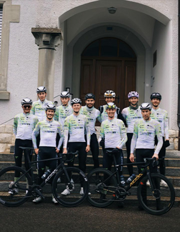 Die Cycling Team Ost Radfahrer in passenden Teamuniformen posieren für ein Foto