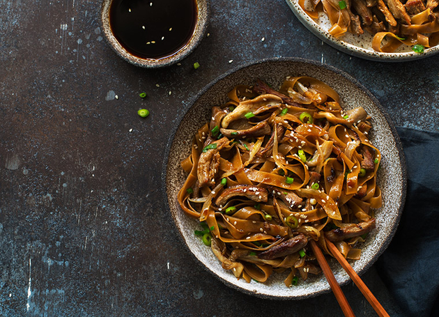 Zwei Schüsseln asiatische Nudeln mit Fleisch.