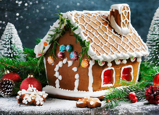 Ein Lebkuchenhaus umgeben von weihnachtilichen Dekorationen