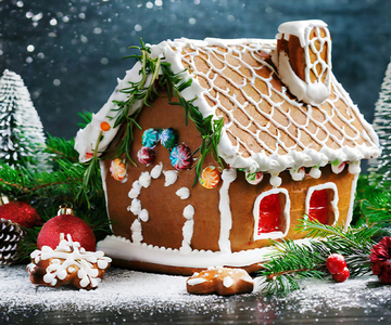 Ein Lebkuchenhaus umgeben von weihnachtilichen Dekorationen