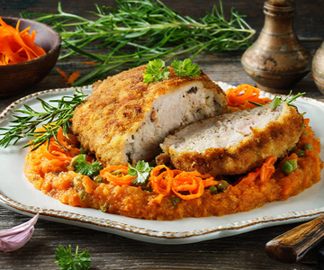 Gefülltes Schweineschnitzel auf einem Rüebliragout garniert mit Rosmarin. 