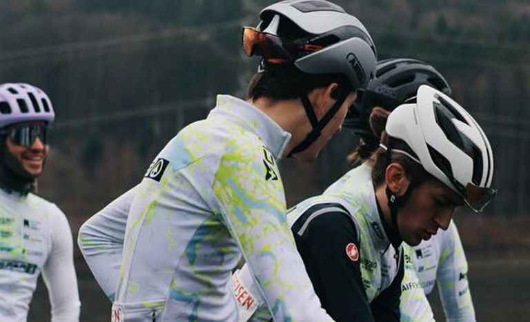Gruppe von Radfahrer des Cycling Team Ost im Gespräch, gekleidet in Sportbekleidung.