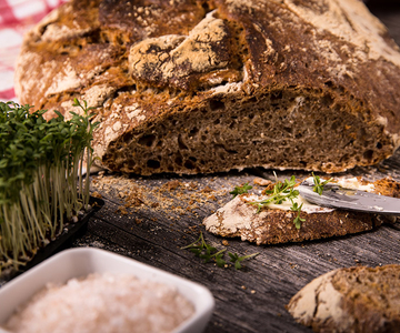 Ein Laib Brot mit Salz und Kräutern auf einem Tisch.